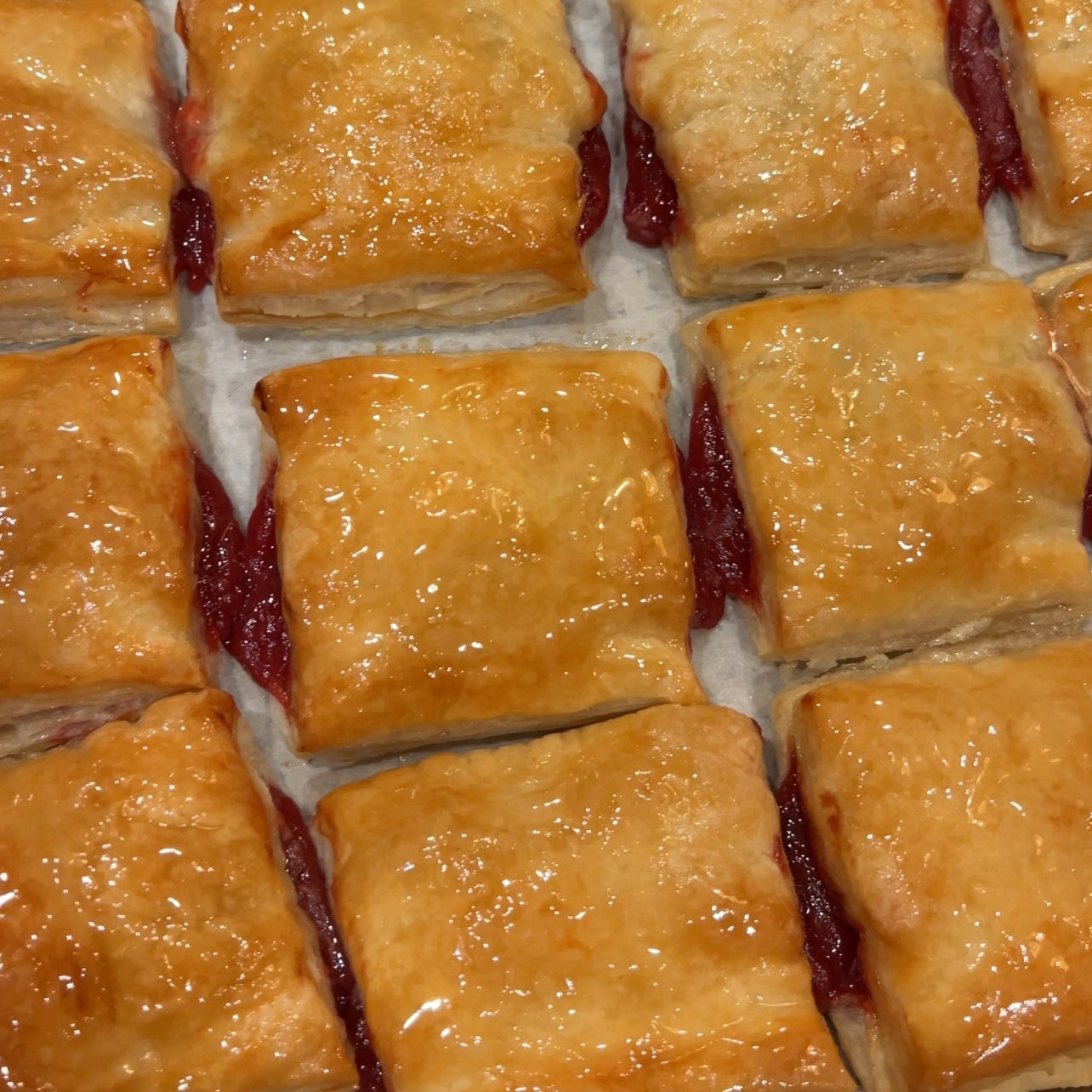 Baked pastries with a golden crust on a baking tray.