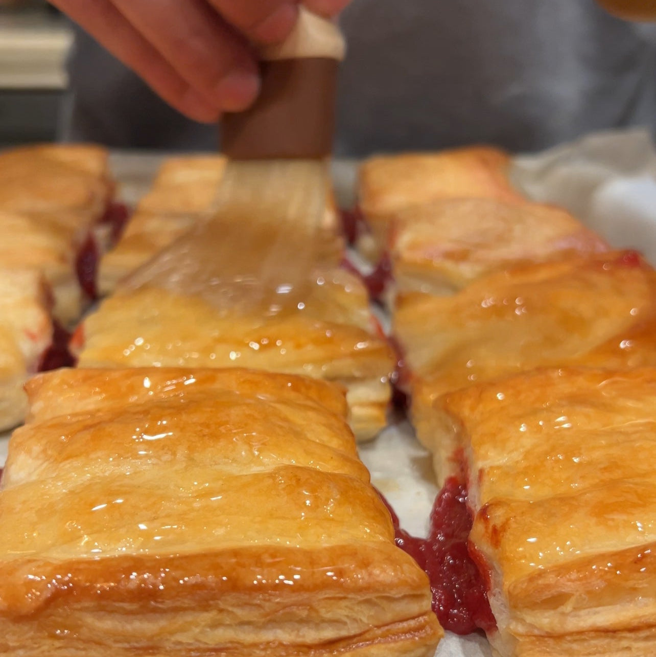 Pastry filled with a guava on a baking sheet.