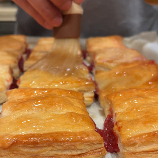 Pastry filled with a guava on a baking sheet.
